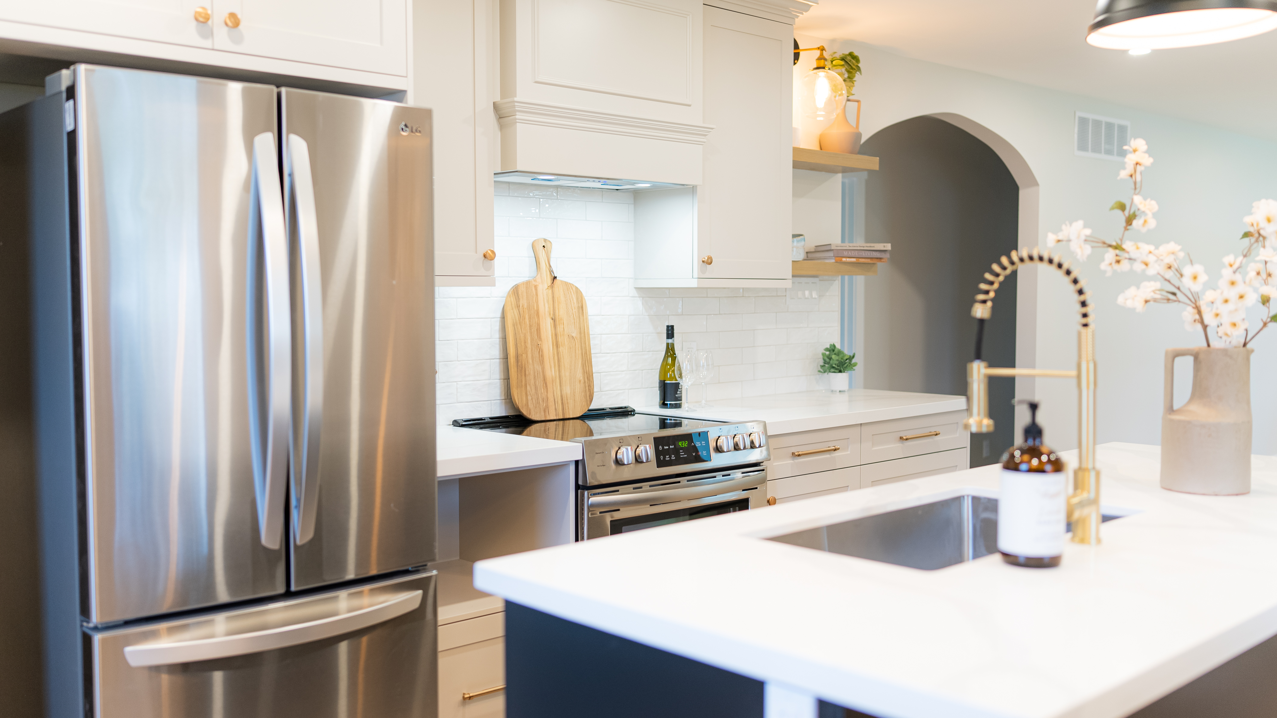Elegant cream kitchen with arched niche and gold hardware